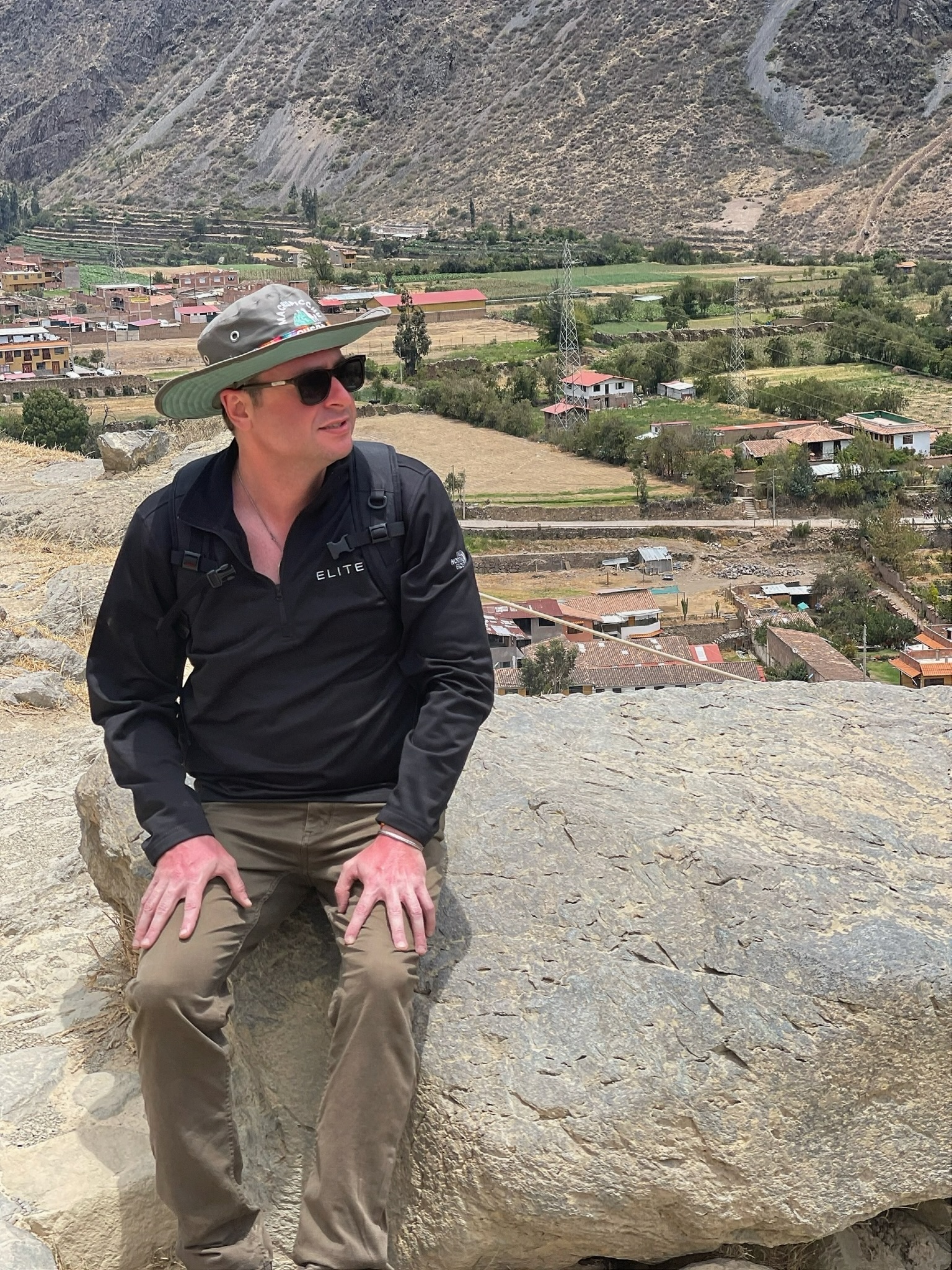 Shaun Southworth sitting on a stone overlook above a valley in Peru